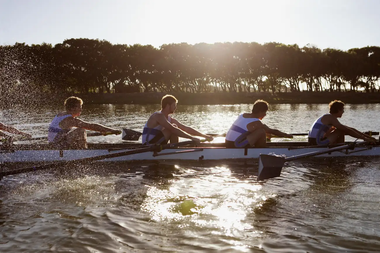 A rowing team moving together at speed on the water